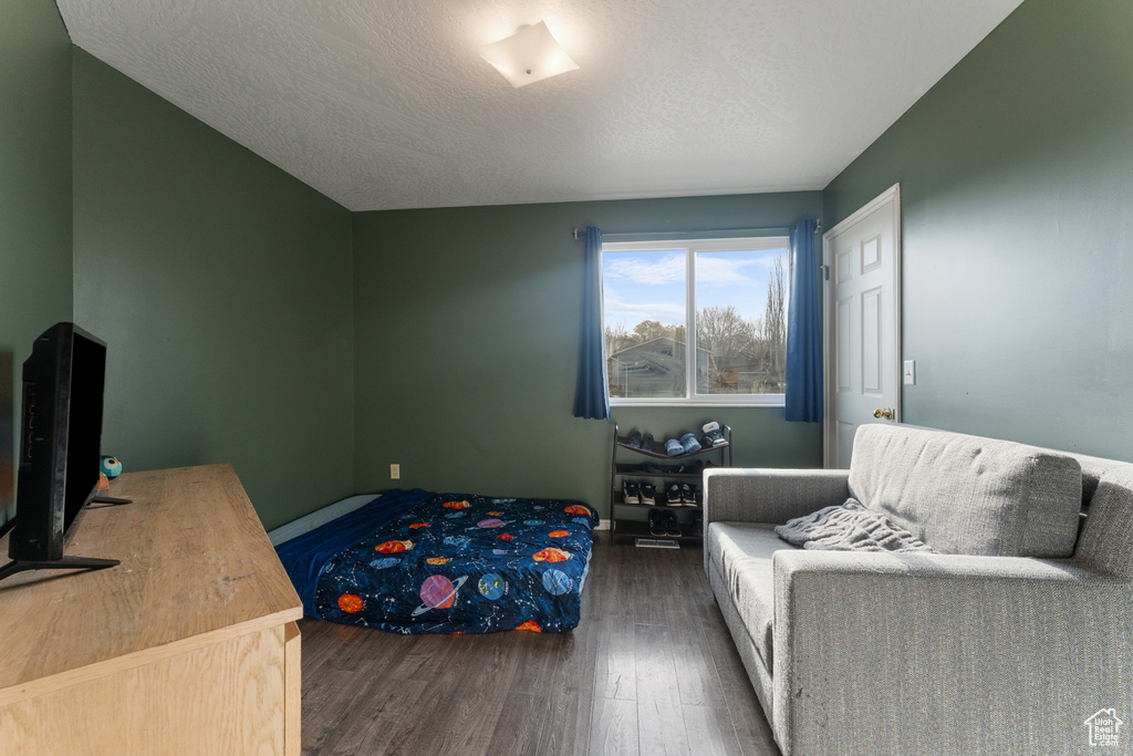 Bedroom with dark wood-type flooring and a textured ceiling