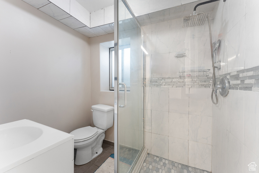 Bathroom with a sink, toilet, a shower stall, and tile patterned flooring