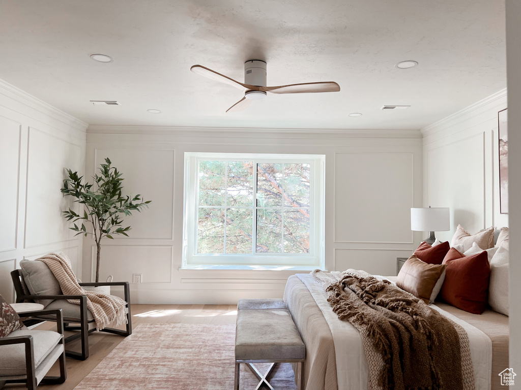 Bedroom with a decorative wall, ceiling fan, ornamental molding, and visible vents