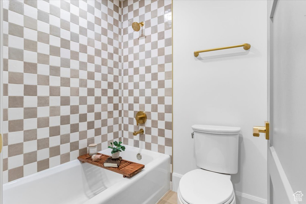 Full bathroom with toilet and baseboards