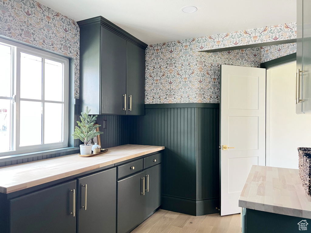 Kitchen with light wood-style floors, plenty of natural light, wainscoting, and wallpapered walls