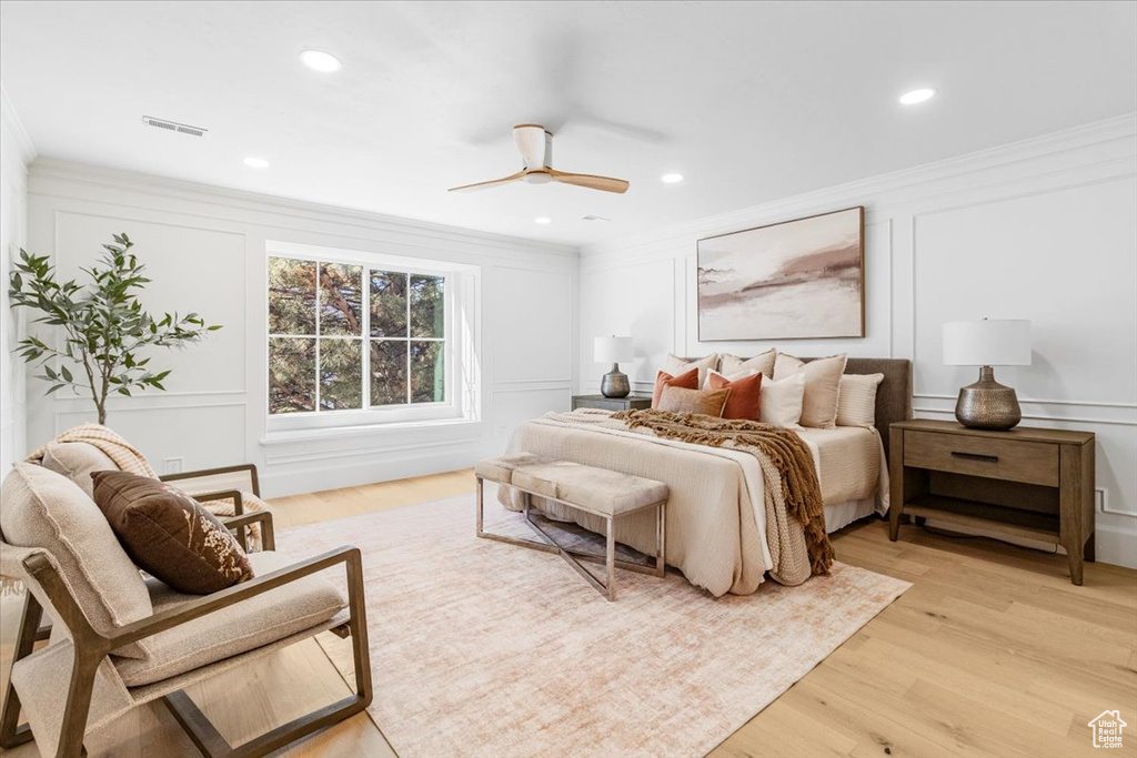 Bedroom featuring a decorative wall, visible vents, and ornamental molding