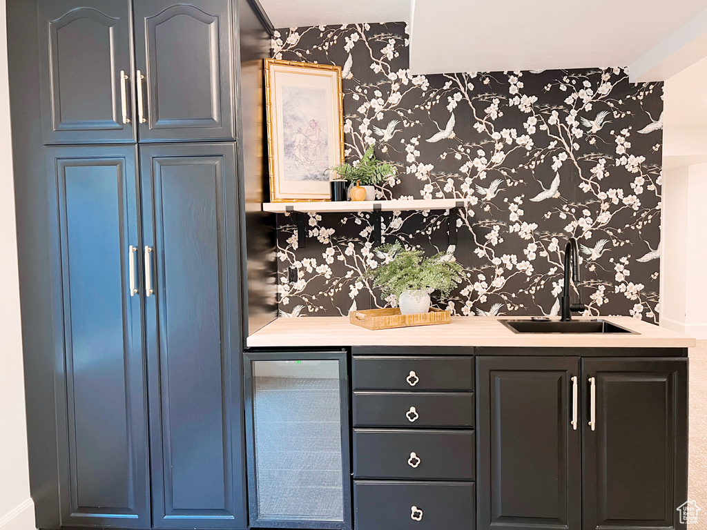 Bar with a sink, indoor wet bar, beverage cooler, and wallpapered walls