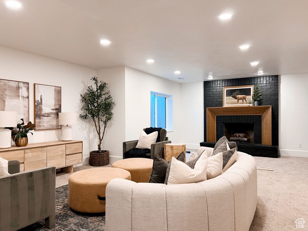 Carpeted living area featuring baseboards, recessed lighting, and a fireplace