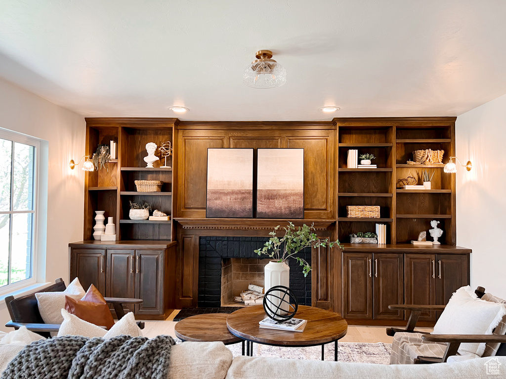 Living area with a fireplace with flush hearth and light wood finished floors