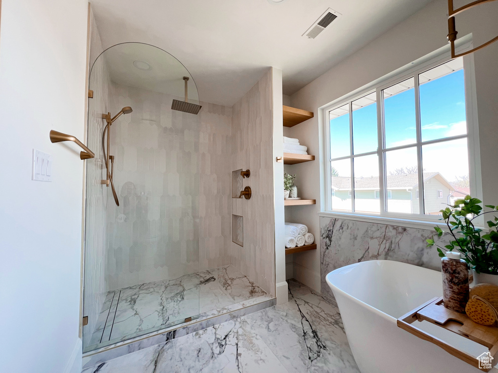 Full bath with visible vents, marble finish floor, a stall shower, and a freestanding tub