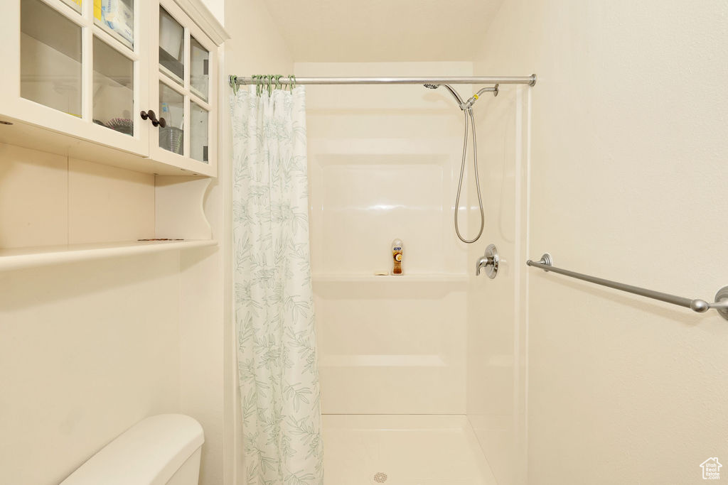 Bathroom featuring toilet and a stall shower
