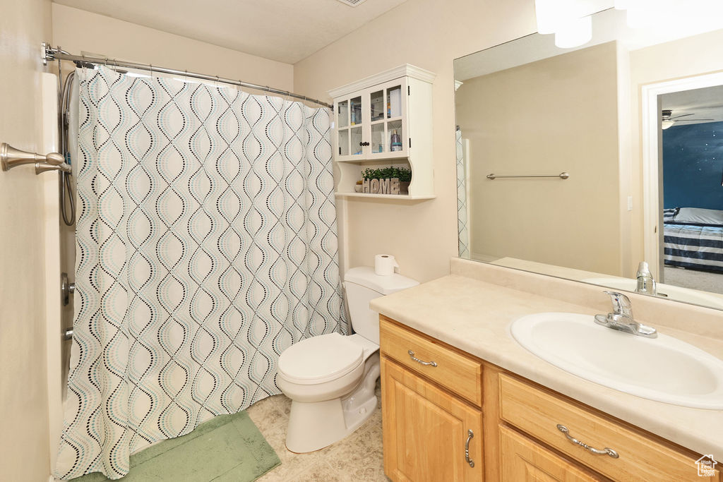 Full bath with curtained shower, vanity, connected bathroom, and toilet