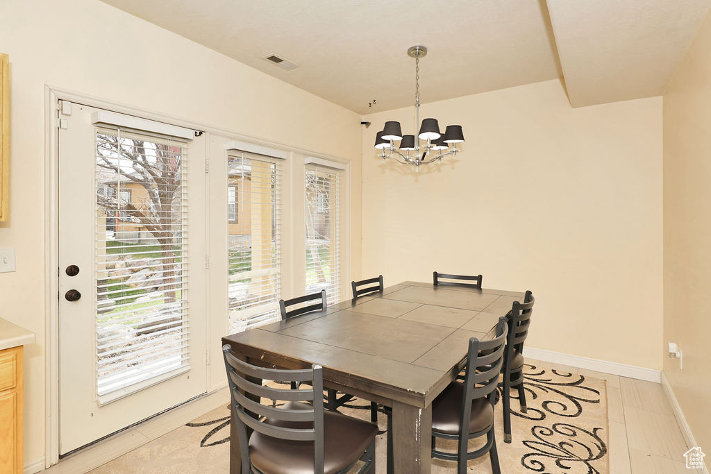 Dining area featuring a notable chandelier and baseboards