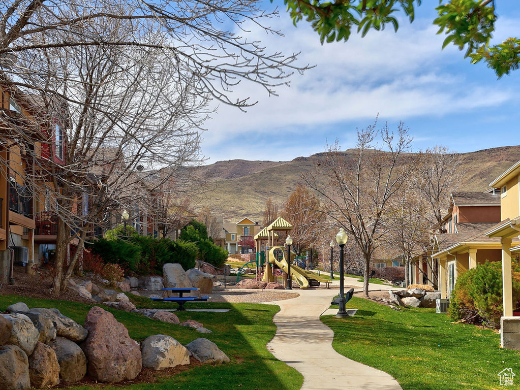 View of community featuring a lawn, a mountain view, and playground community