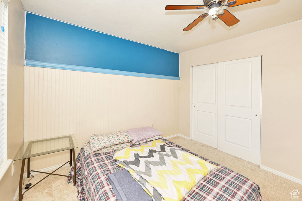 Bedroom featuring a closet, ceiling fan, carpet, and baseboards