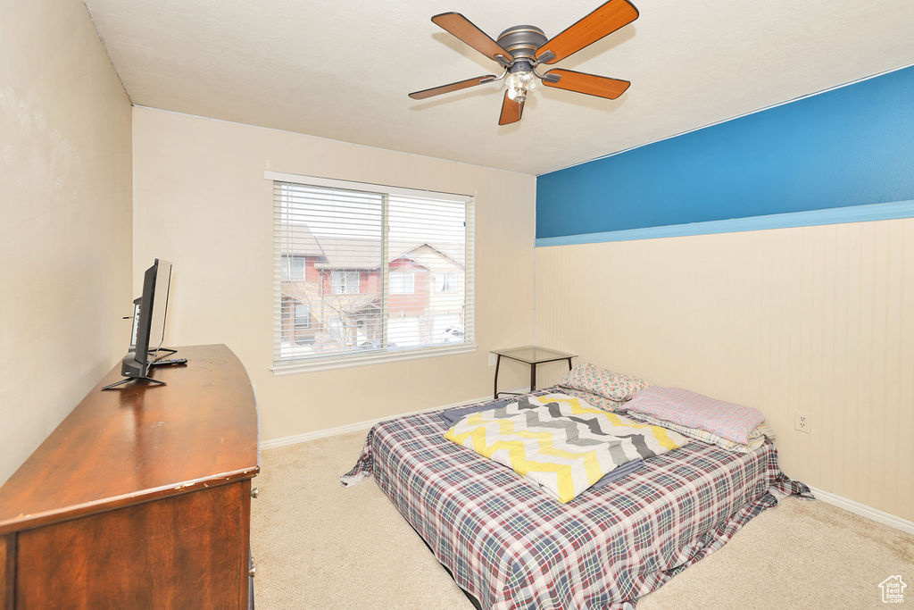 Carpeted bedroom featuring baseboards and a ceiling fan
