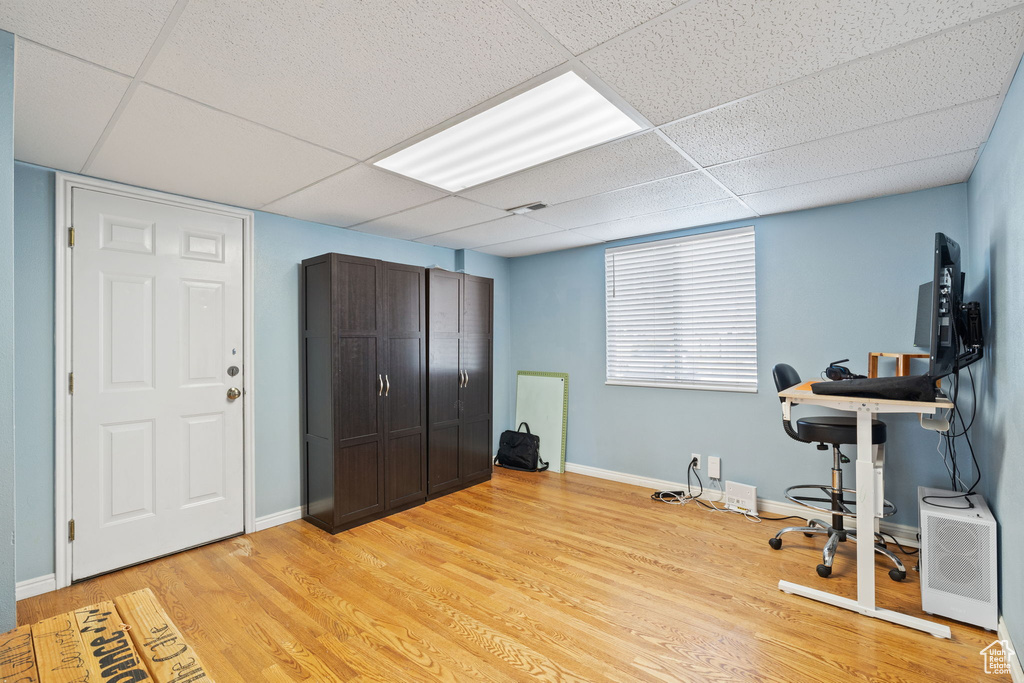 Office space featuring light wood-style flooring, a drop ceiling, baseboards, and visible vents