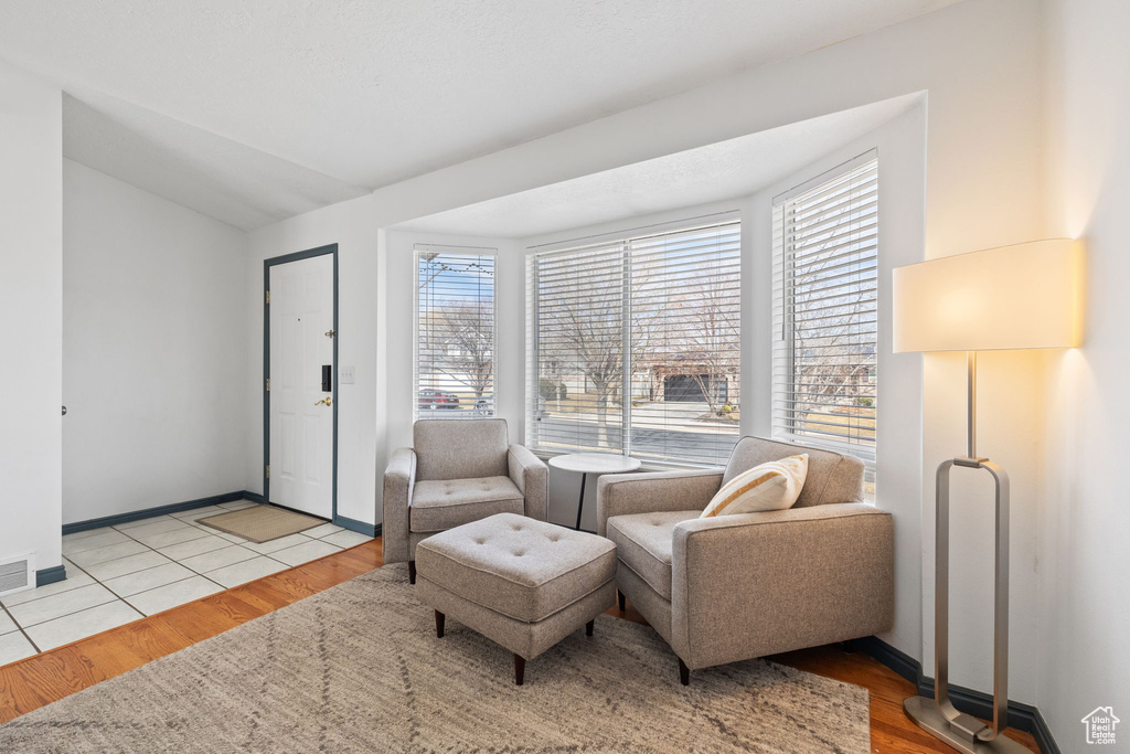 Living area featuring baseboards, vaulted ceiling, and wood finished floors