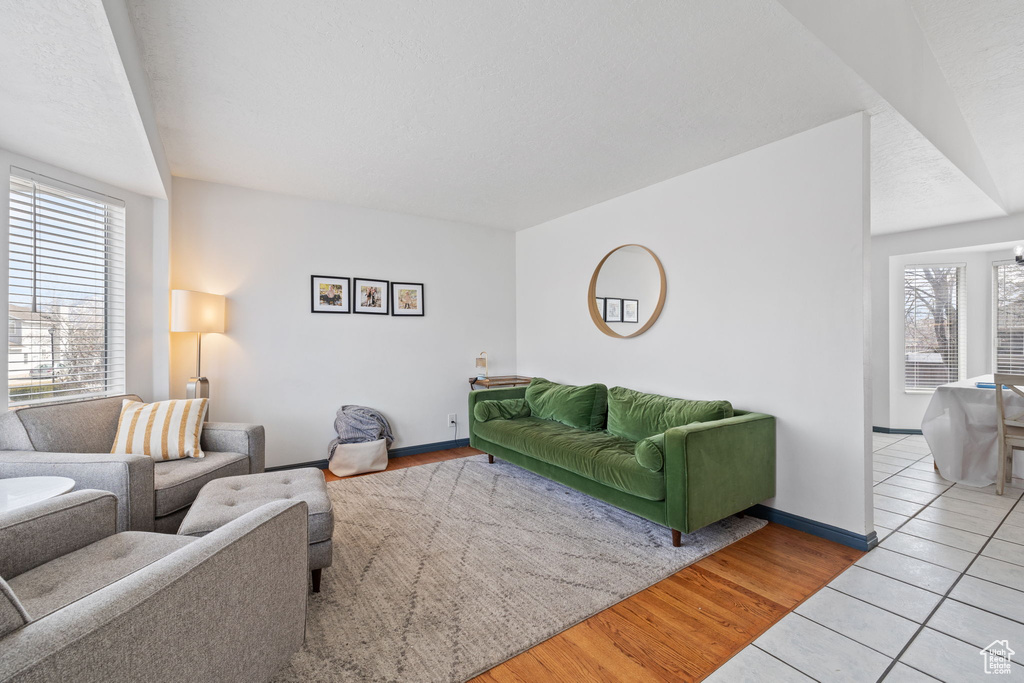 Living room featuring tile patterned floors, a healthy amount of sunlight, and baseboards