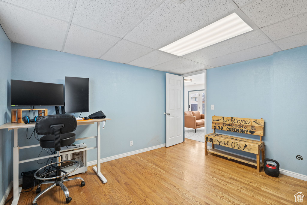 Office with a paneled ceiling, wood finished floors, and baseboards