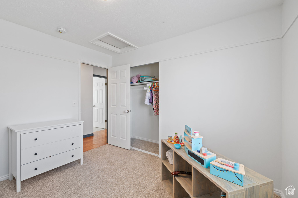 Bedroom featuring attic access, carpet flooring, a closet, and baseboards