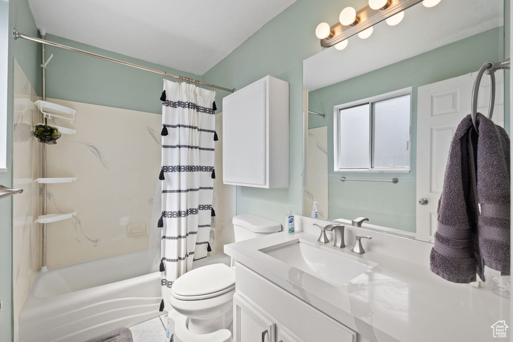Full bath with toilet, shower / bathtub combination with curtain, and vanity