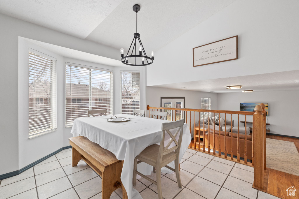 Dining room with an inviting chandelier, baseboards, and light tile patterned floors