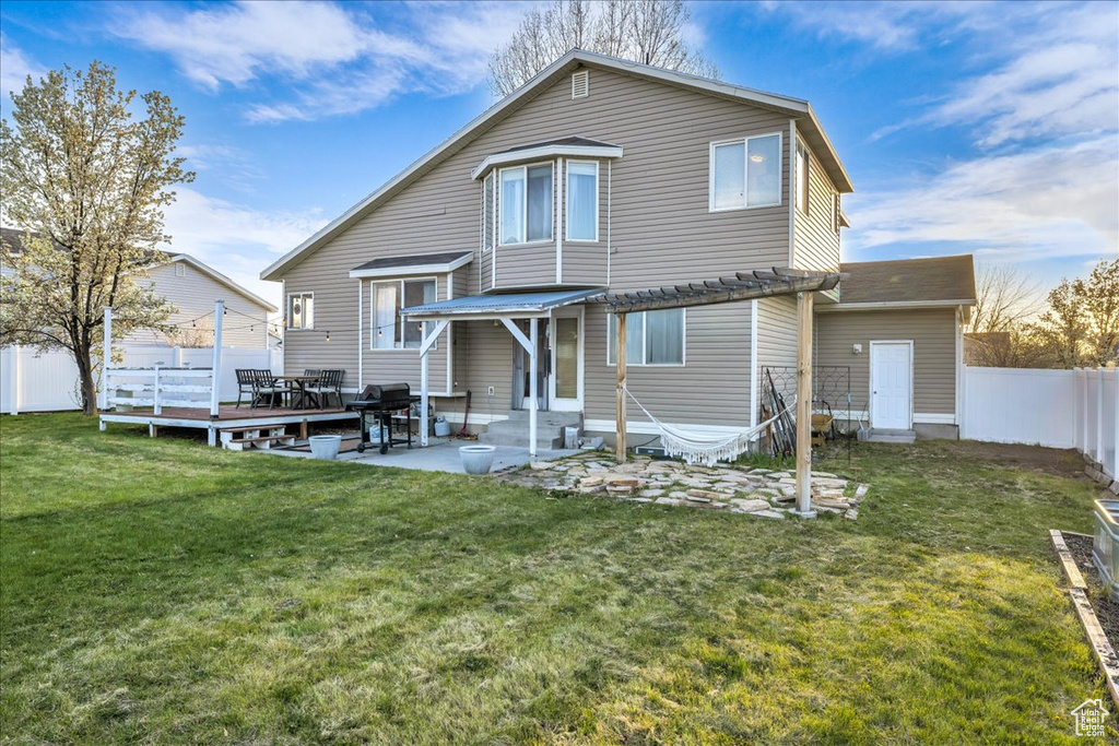 Rear view of property with entry steps, a yard, a fenced backyard, and a pergola