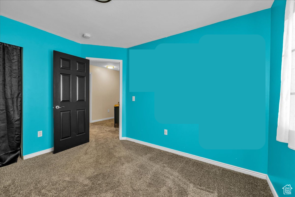 Unfurnished bedroom featuring baseboards and carpet