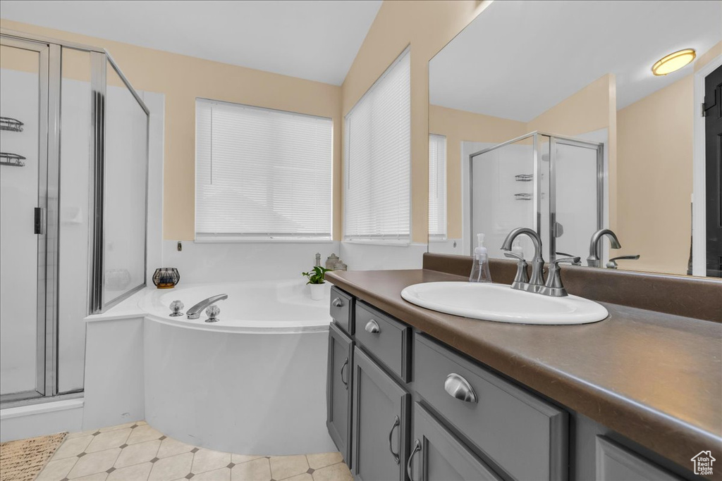 Bathroom featuring a shower stall, a garden tub, and vanity