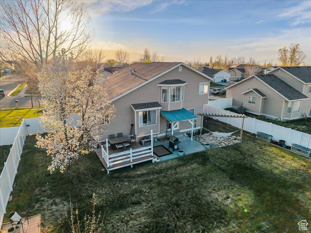Back of house with a yard, a fenced backyard, a residential view, and a patio area