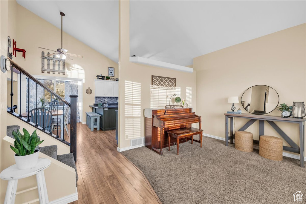 Interior space with baseboards, vaulted ceiling, visible vents, ceiling fan, and wood finished floors