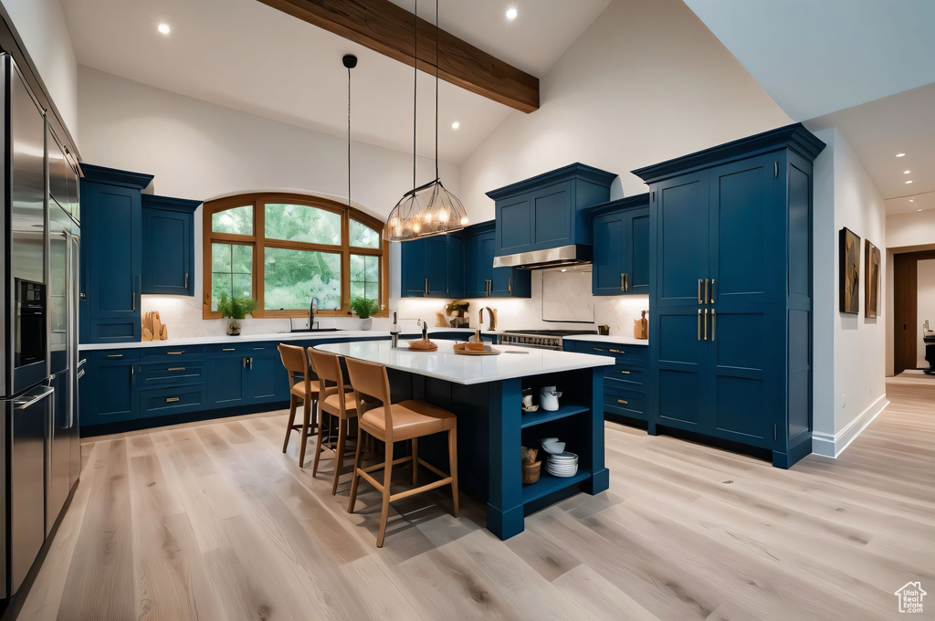 Kitchen with blue cabinets, light countertops, stainless steel built in refrigerator, light wood-style flooring, and recessed lighting