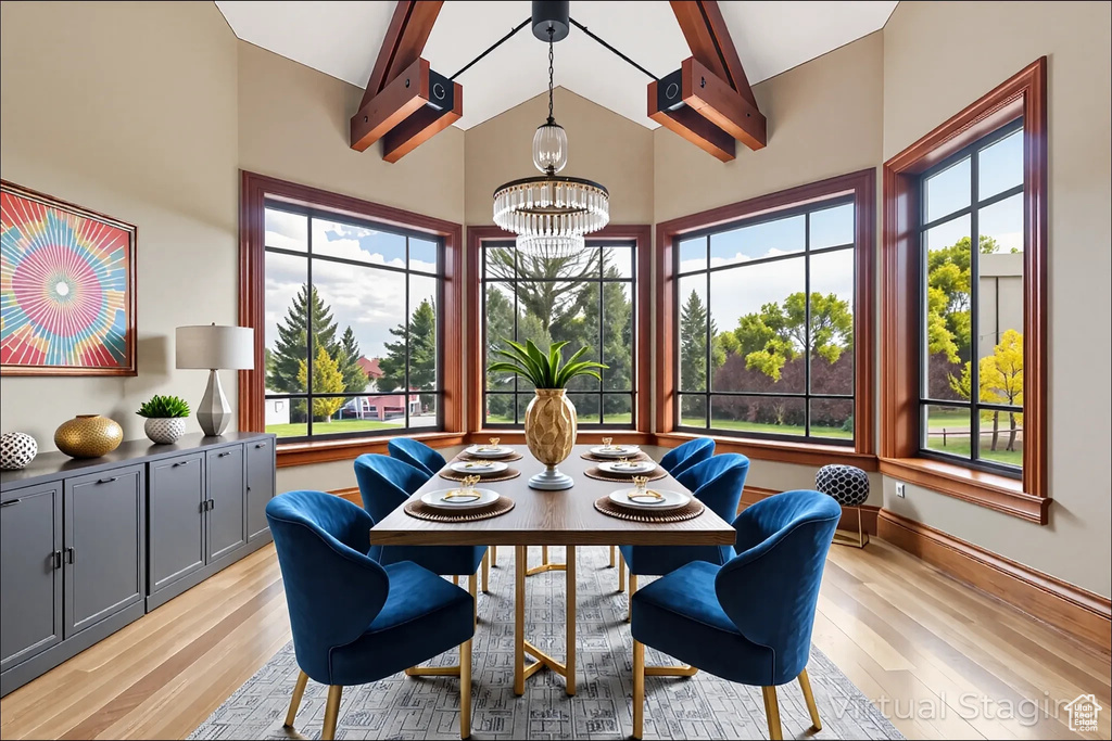 Dining space with a chandelier, light wood-style flooring, beam ceiling, and high vaulted ceiling