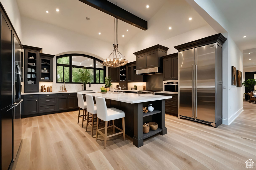 Kitchen with appliances with stainless steel finishes, open shelves, light countertops, recessed lighting, and light wood-type flooring