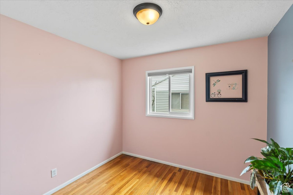 Unfurnished room with light wood finished floors and baseboards