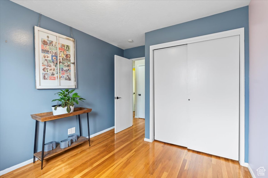 Bedroom with a closet, baseboards, and wood finished floors