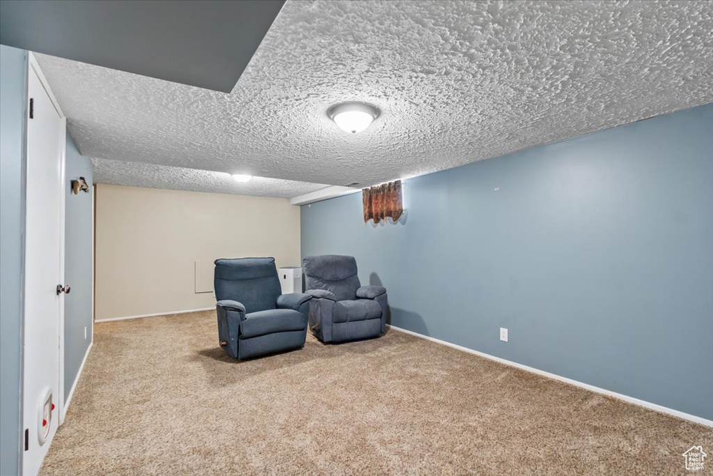 Unfurnished room featuring a textured ceiling, baseboards, and carpet floors
