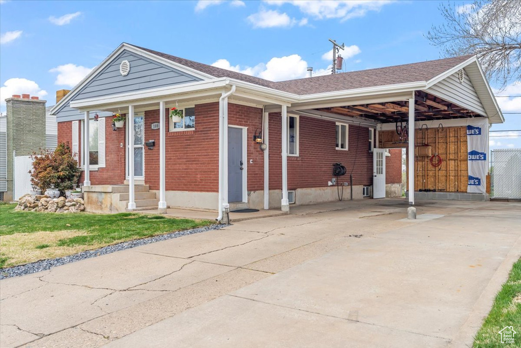 Single story home featuring brick siding and concrete driveway