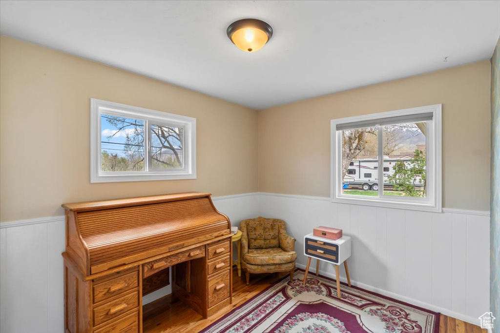 Office with a wainscoted wall and wood finished floors
