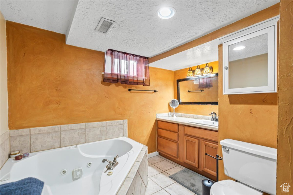 Full bath with vanity, tile patterned flooring, toilet, visible vents, and a tub with jets