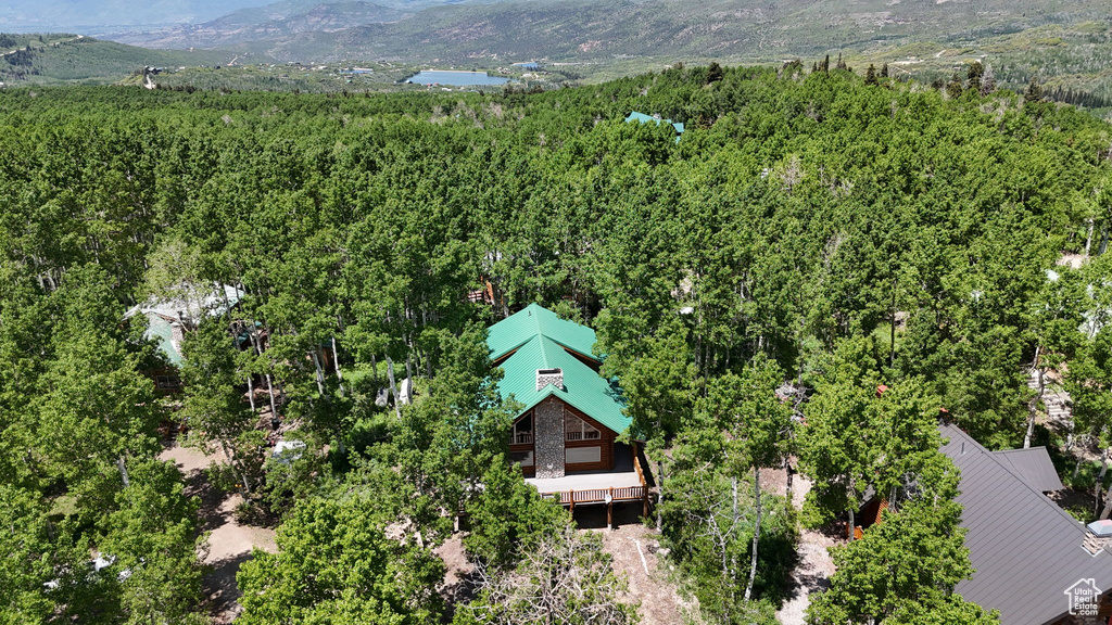 Aerial view of property and surrounding area with a heavily wooded area and mountains