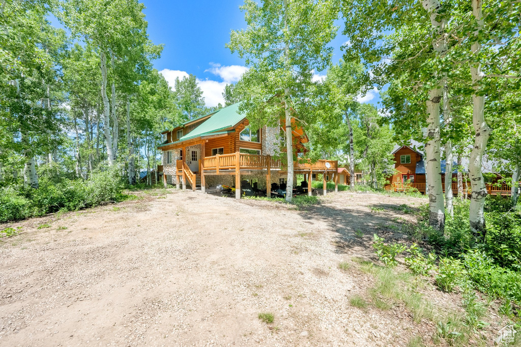 View of front of house featuring a wooden deck and metal roof