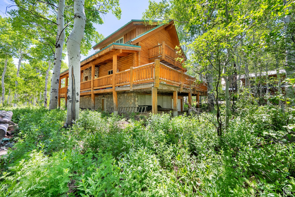 Back of house featuring stone siding, board and batten siding, and a deck
