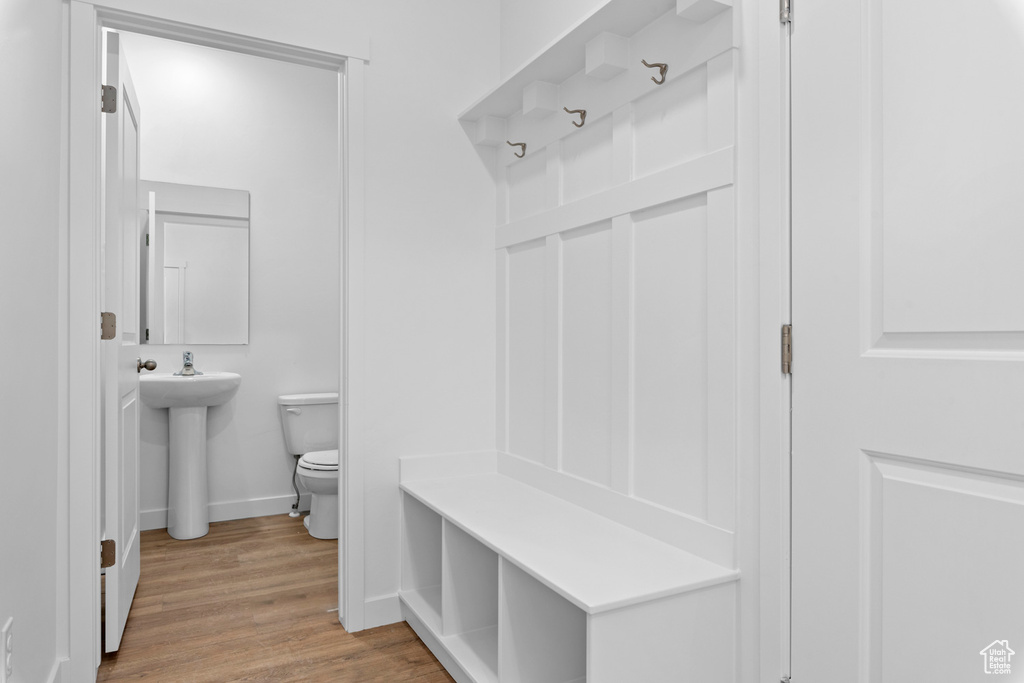 Mudroom featuring wood finished floors, a sink, and baseboards