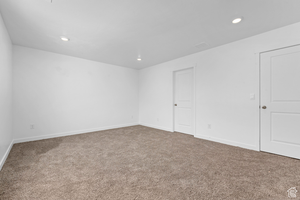 Empty room featuring baseboards, recessed lighting, and carpet