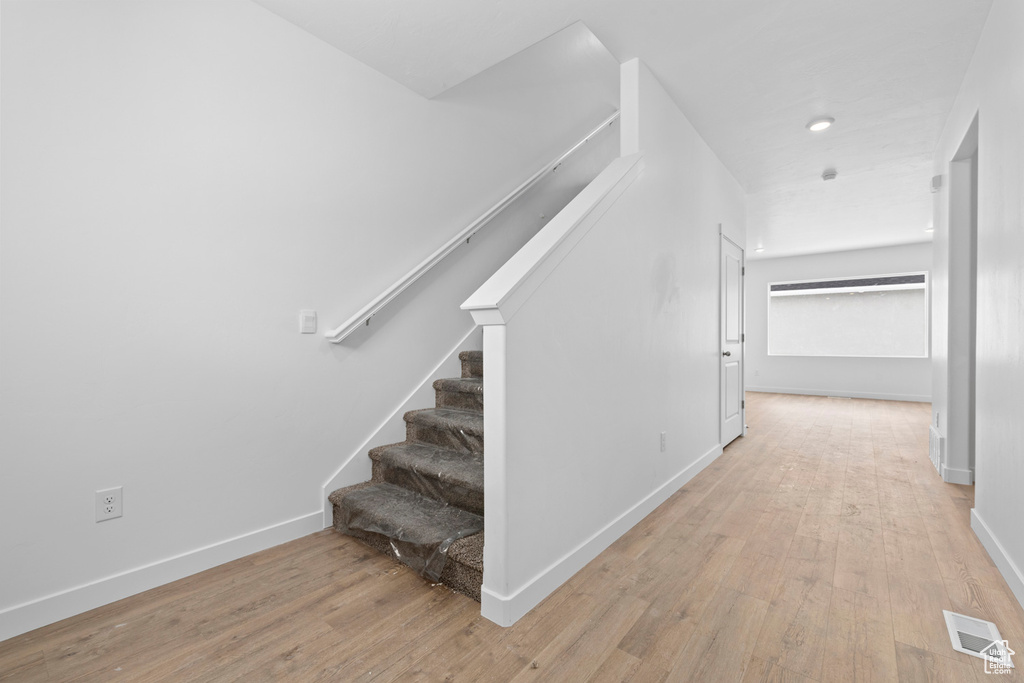 Stairs featuring visible vents, baseboards, and wood finished floors
