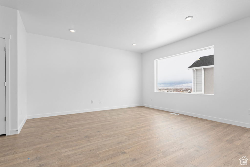 Empty room with baseboards, recessed lighting, and wood finished floors