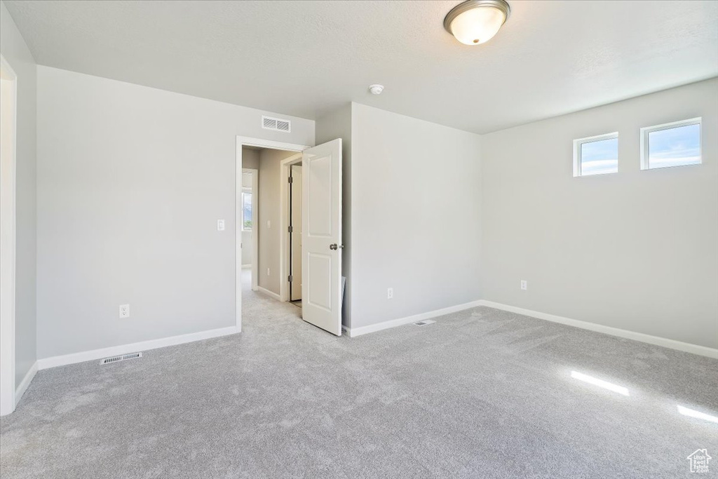 Empty room with visible vents, baseboards, and carpet floors