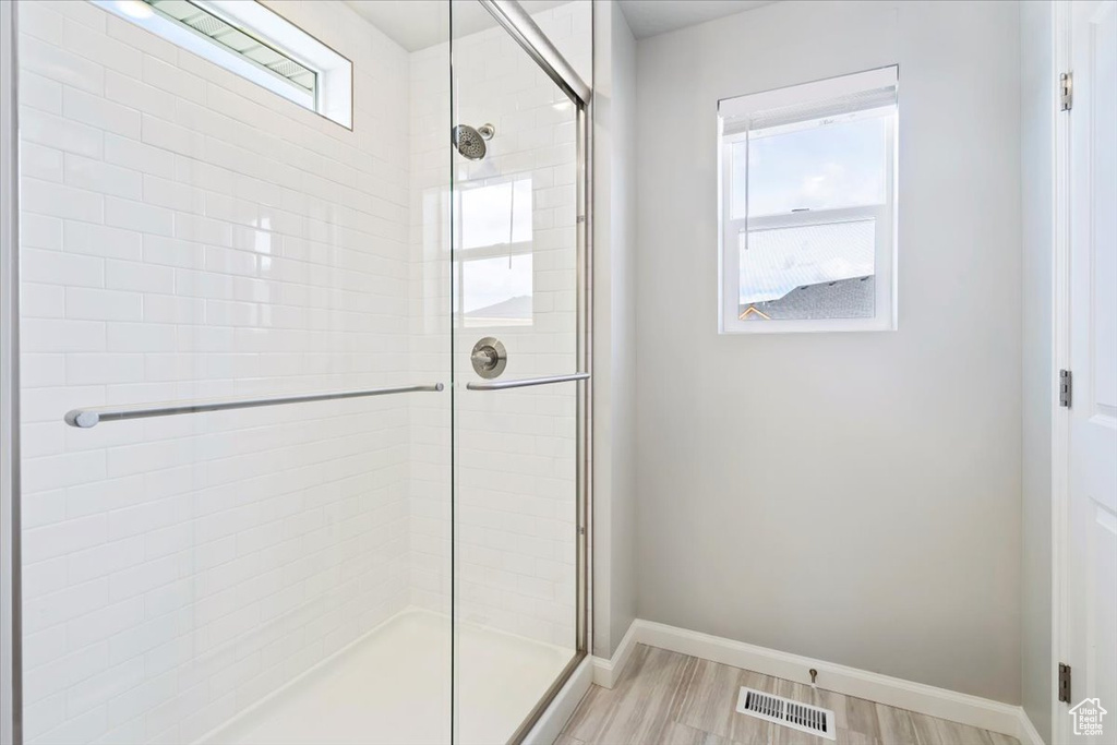 Bathroom featuring a stall shower, baseboards, and visible vents