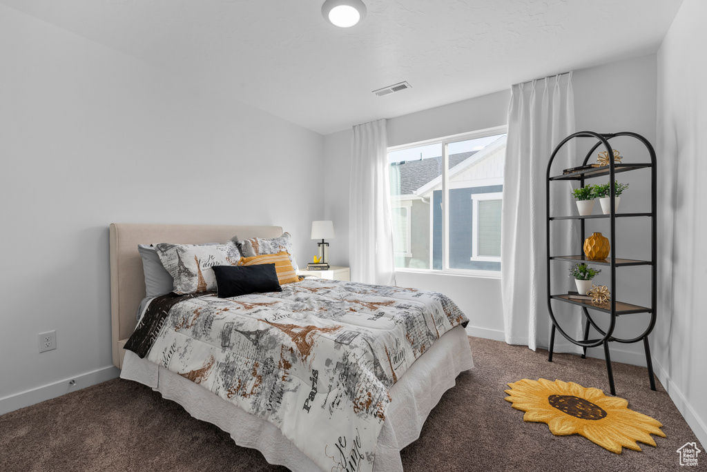 Carpeted bedroom featuring visible vents and baseboards