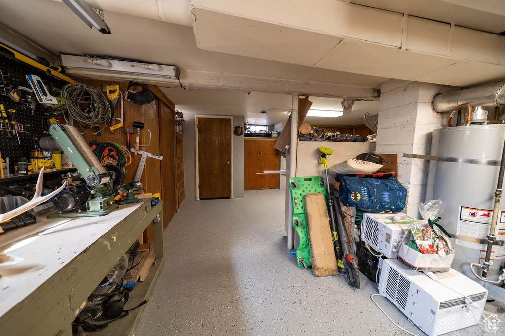 Finished below grade area featuring secured water heater and a workshop area