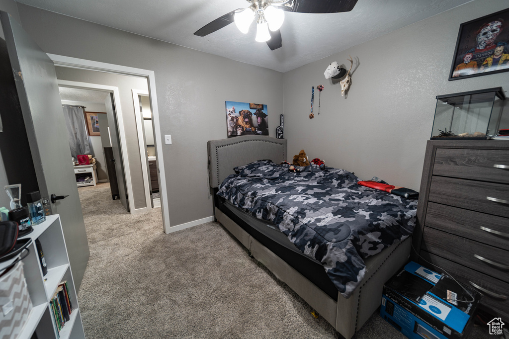 Bedroom with ceiling fan, light carpet, and baseboards