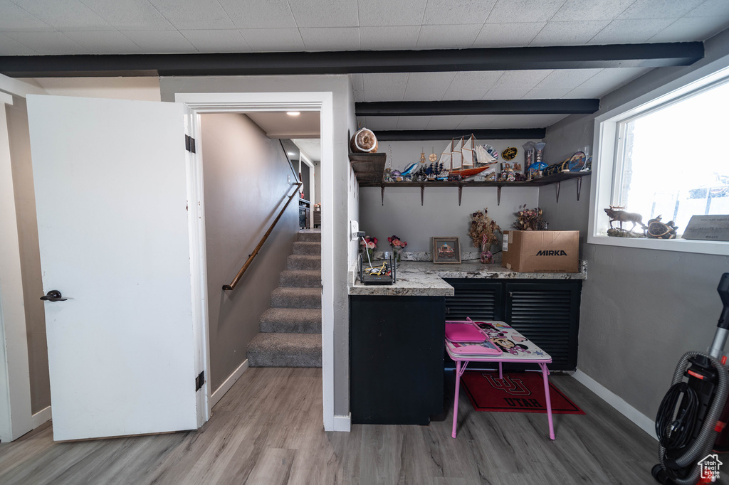 Interior space with indoor bar, baseboards, light wood finished floors, and stairs